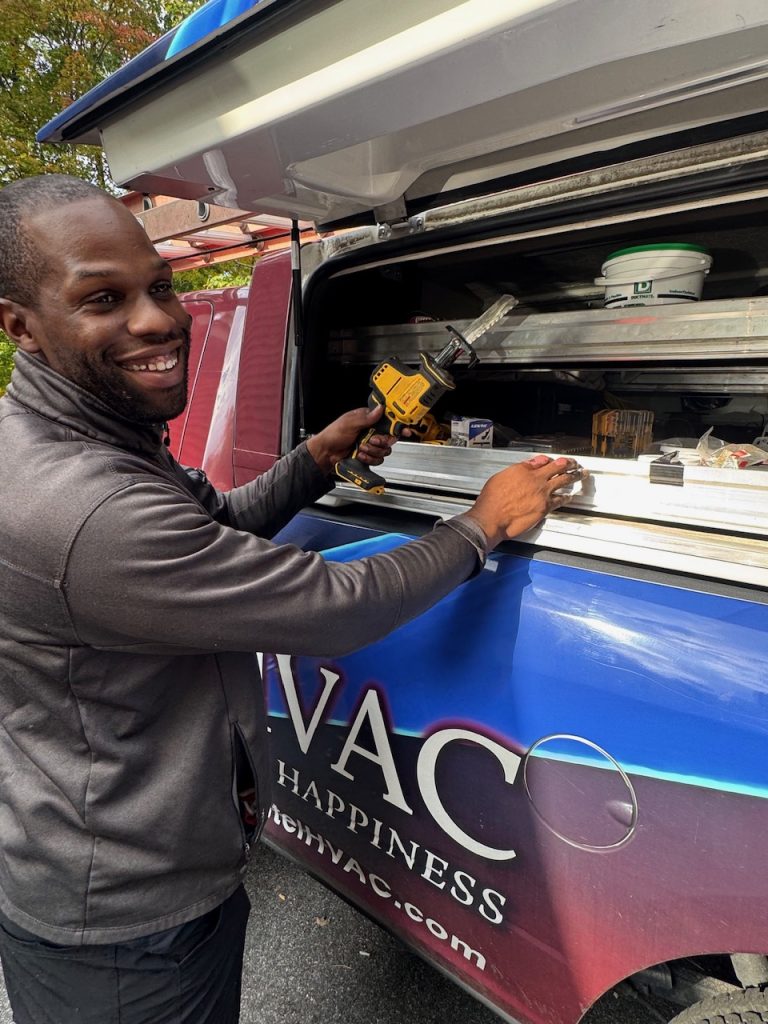 Bantel HVAC technician working beside a branded service vehicle